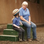 helper and rider sitting on mounting block in conversation