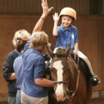 Child on pony 'high five'