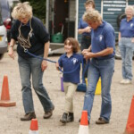 Volunteers helping child with game
